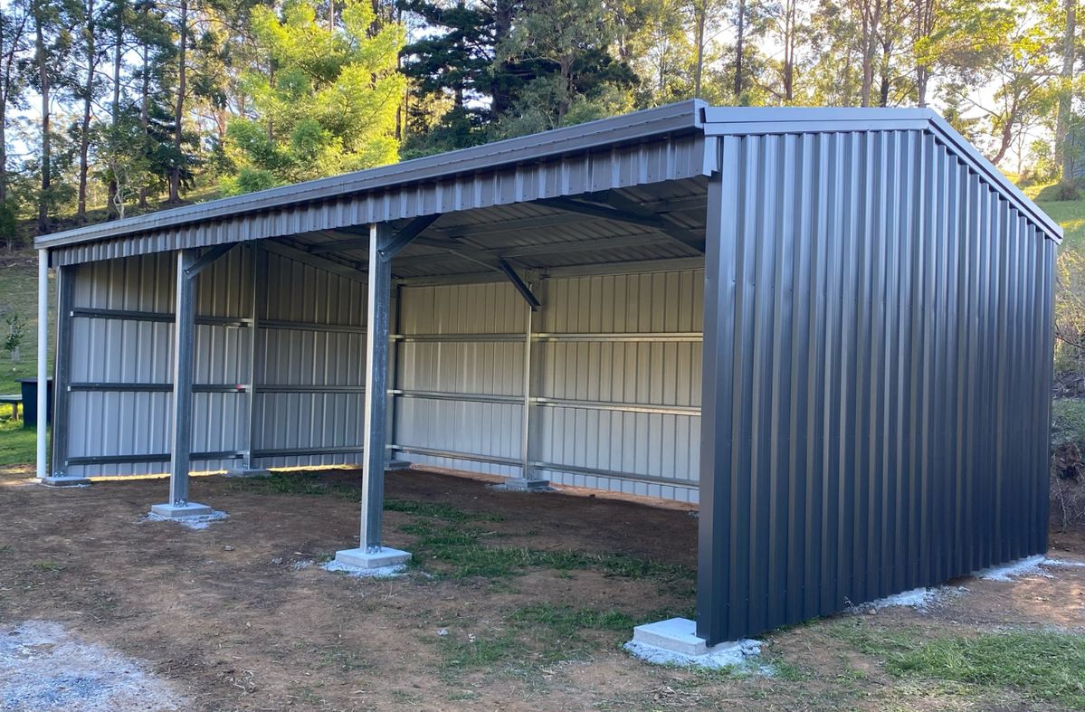 Abri métallique ouvert en tôle grise sur plots béton