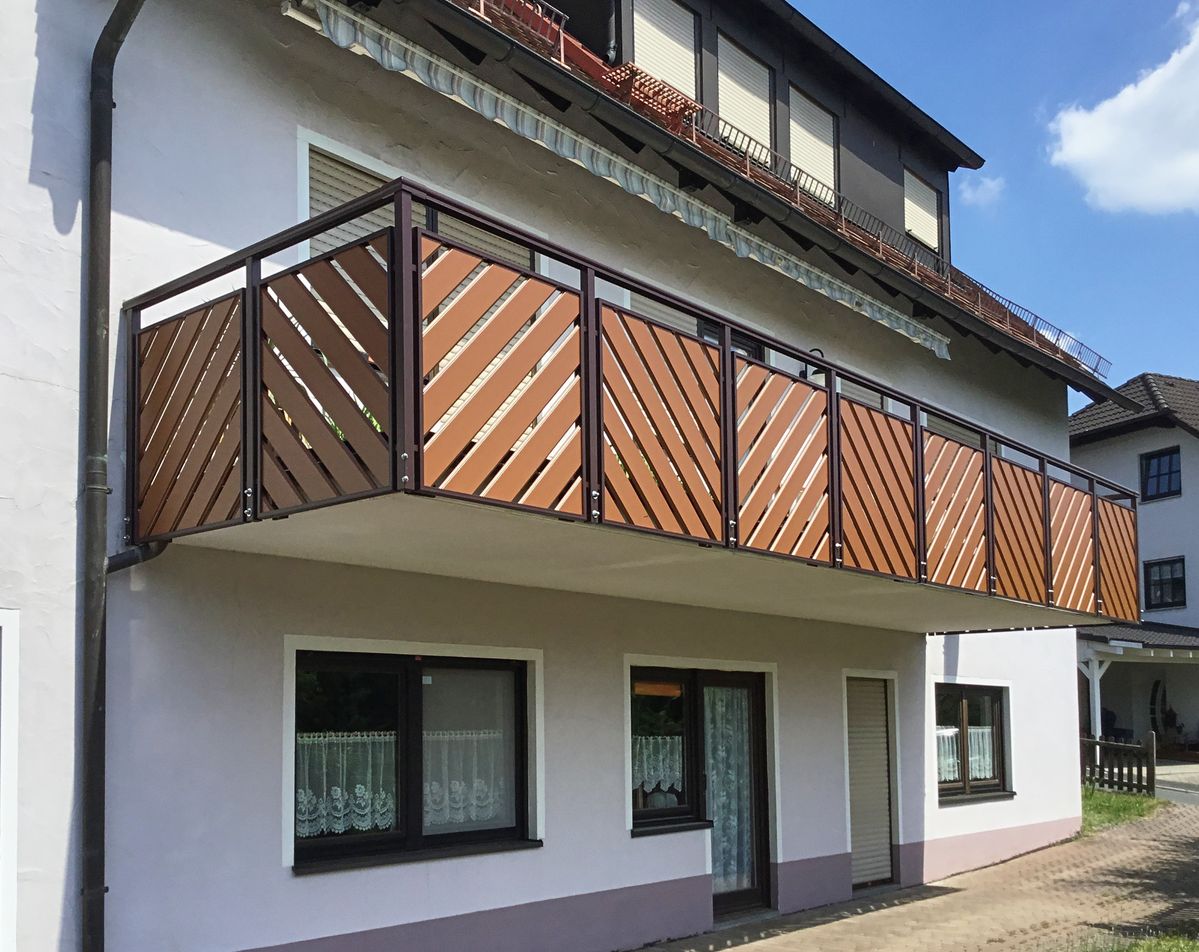 Balcon garde-corps lames diagonales couleur cuivre sur façade