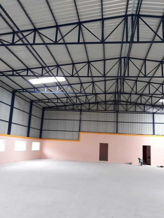 Intérieur grand hangar fini charpente bleue et murs peints