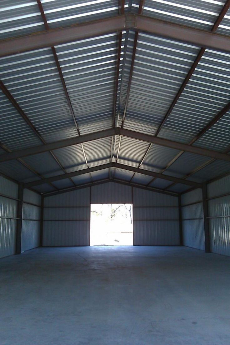 Intérieur hangar métallique toiture claire avec ouverture arrière
