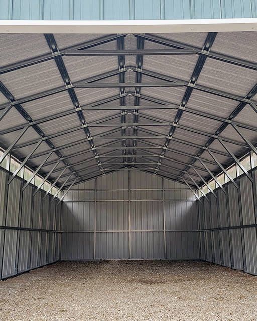 Intérieur hangar métallique toiture profonde charpente sombre