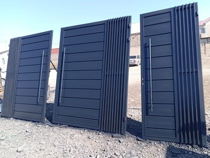 Trois portes métalliques noires à lames horizontales avec poignées inox