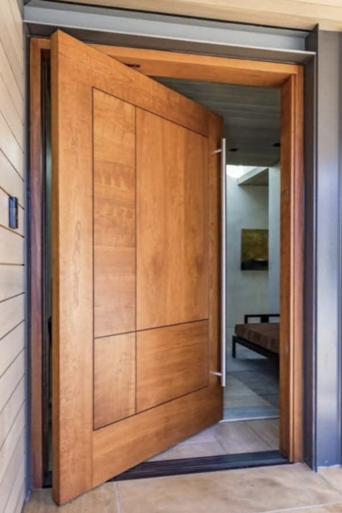 Grande porte pivotante en bois massif avec poignée noire