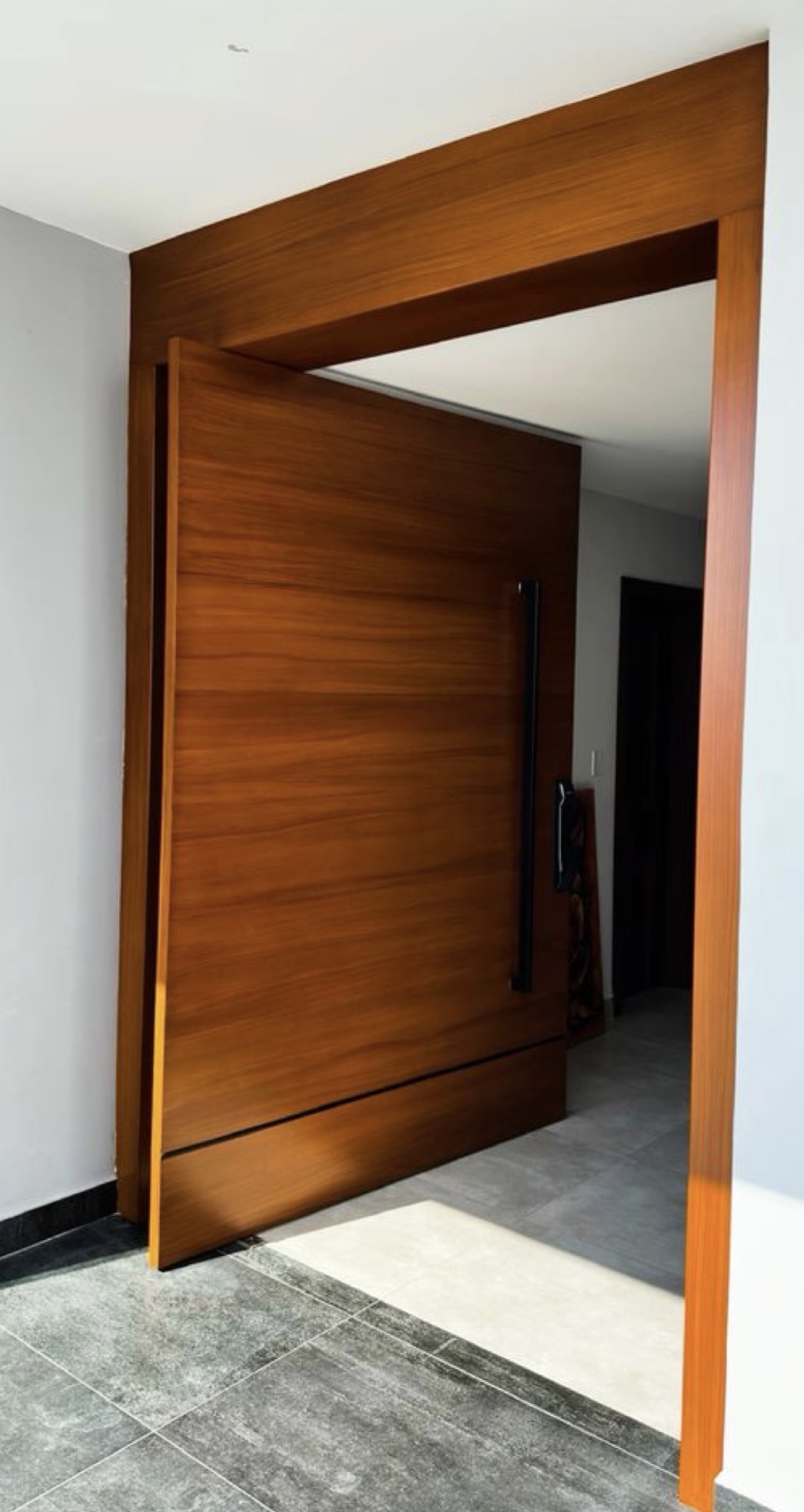 Porte pivotante en bois massif à panneaux poignée inox