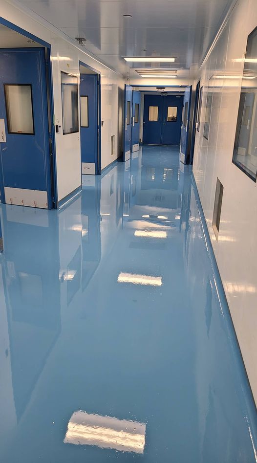 Sol époxy bleu clair brillant dans couloir de salle blanche portes bleues